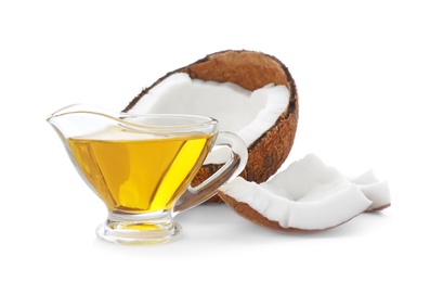 Ripe coconut and gravy boat with oil on white background. Healthy cooking