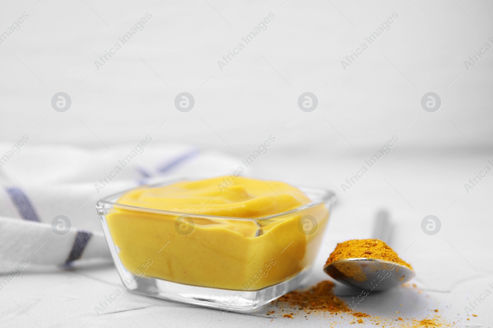 Photo of Tasty curry sauce and powder on white table, closeup