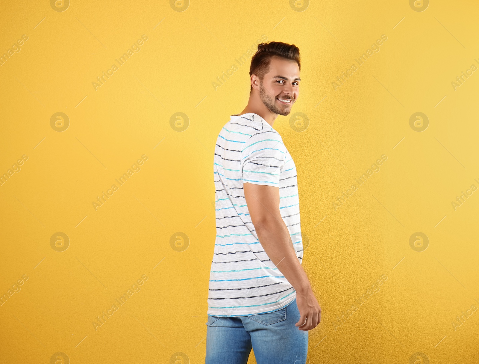 Photo of Young man in stylish jeans on color background