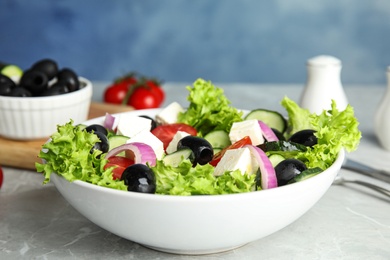 Photo of Tasty fresh Greek salad on grey marble table