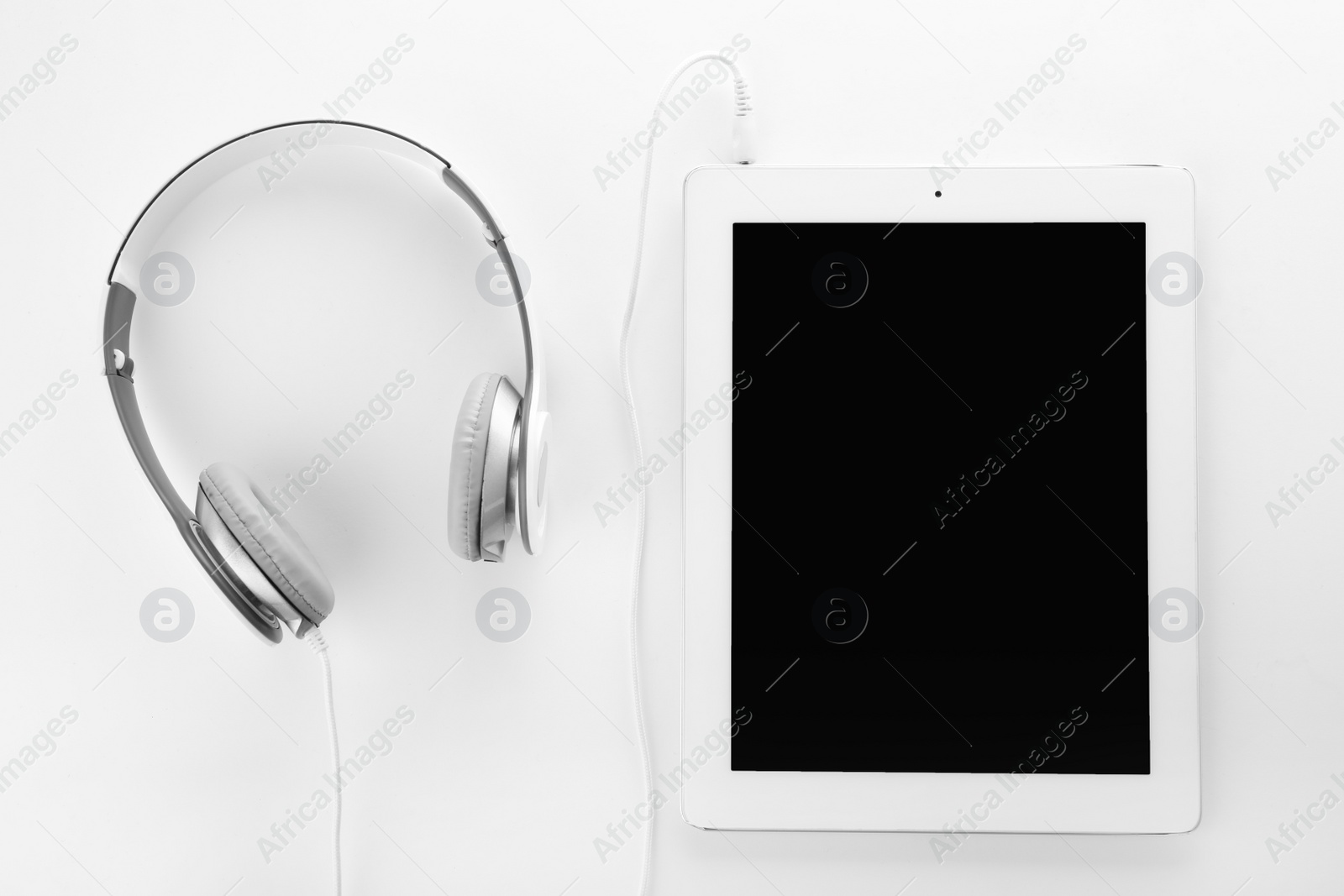 Photo of Tablet with blank screen and headphones on white background, top view