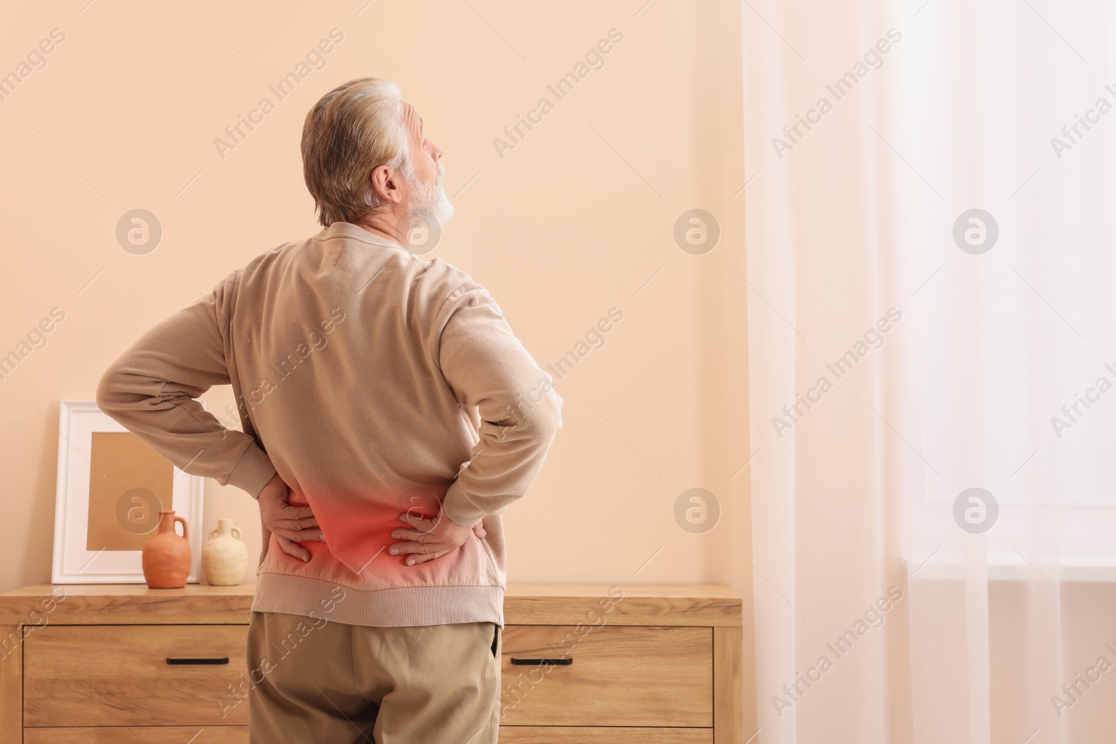 Image of Senior man suffering from pain in lower back at home