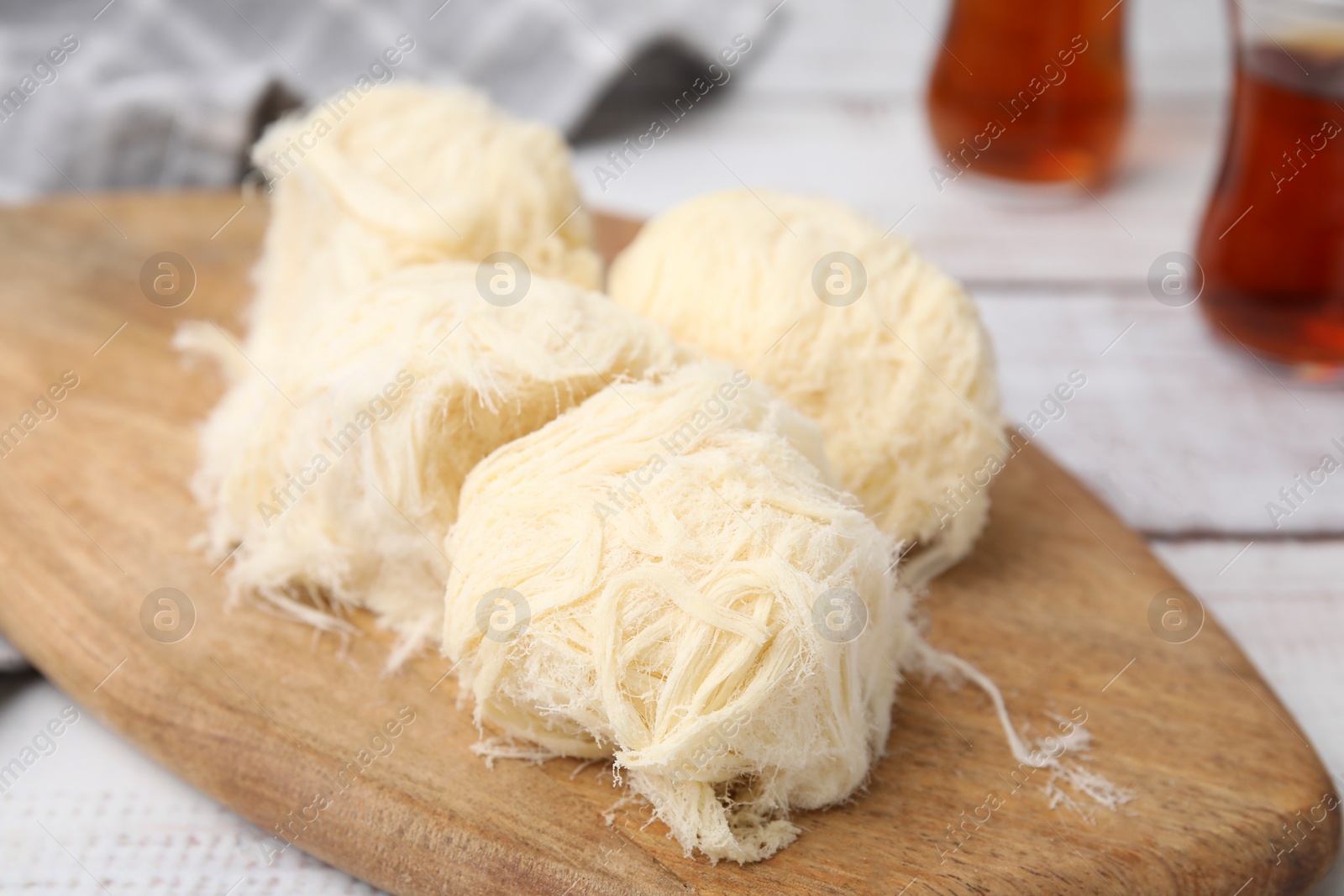 Photo of Eastern sweets. Tasty Iranian pashmak on white wooden table, closeup