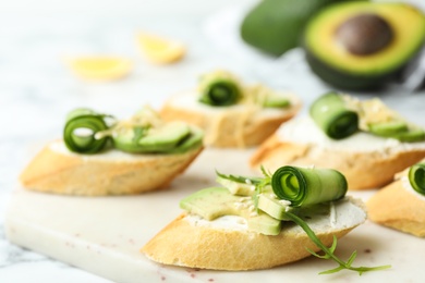 Photo of Delicious sandwiches with cucumber and avocado on white table