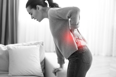 Image of Woman suffering from back pain at home. Bad posture problem