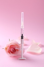Photo of Cosmetology. Medical syringe, rose flower and petals on pink background