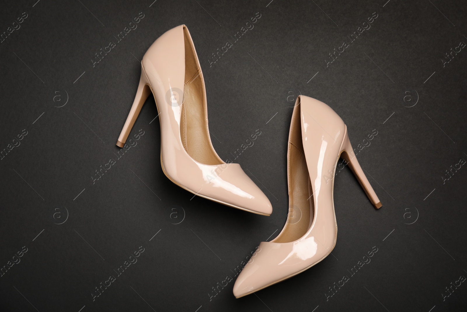 Photo of Pair of beautiful shoes on dark background, top view