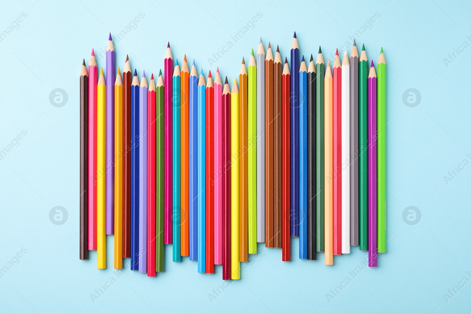 Photo of Colorful wooden pencils on light blue background, flat lay