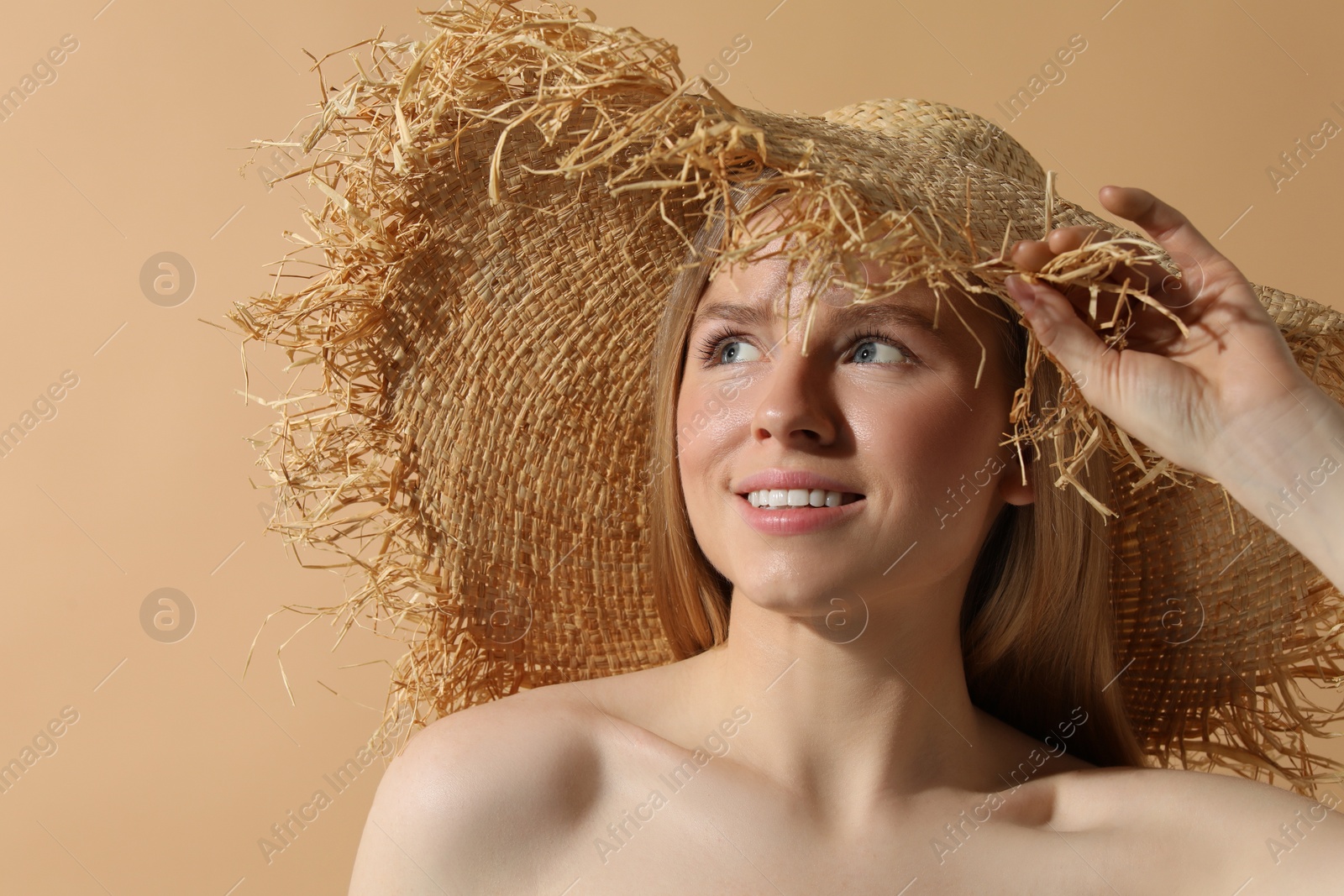 Photo of Beautiful young woman in straw hat on beige background