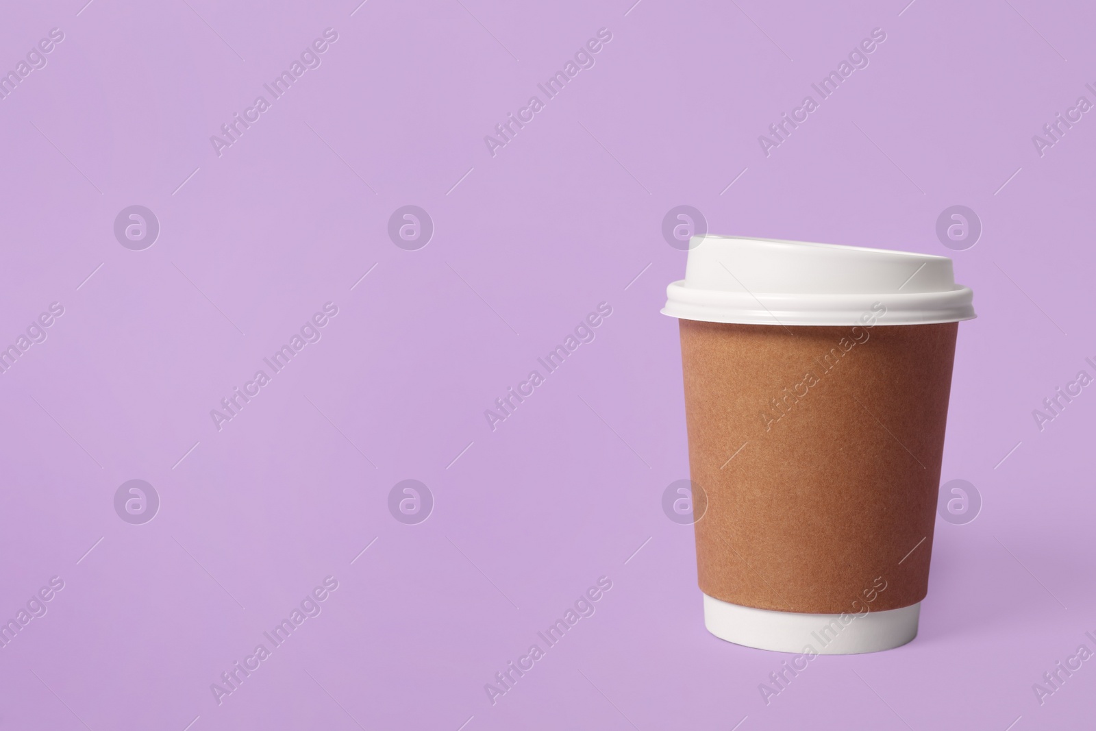 Photo of Takeaway paper coffee cup on violet background. Space for text
