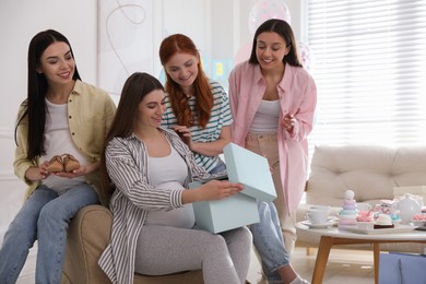 Happy pregnant woman spending time with friends at baby shower party