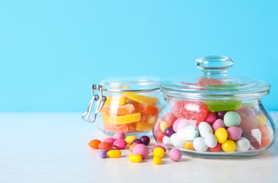 Photo of Different yummy candies on light blue background. Space for text