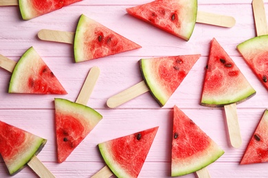 Flat lay composition with watermelon popsicles on wooden background