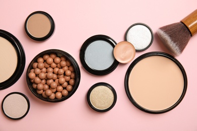 Photo of Flat lay composition with various makeup face powders on color background