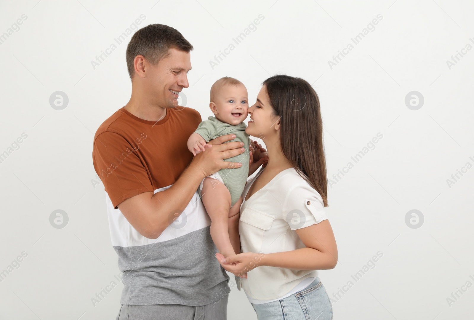 Photo of Portrait of happy family with their cute baby on white background