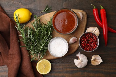 Fresh marinade and ingredients on wooden table, flat lay