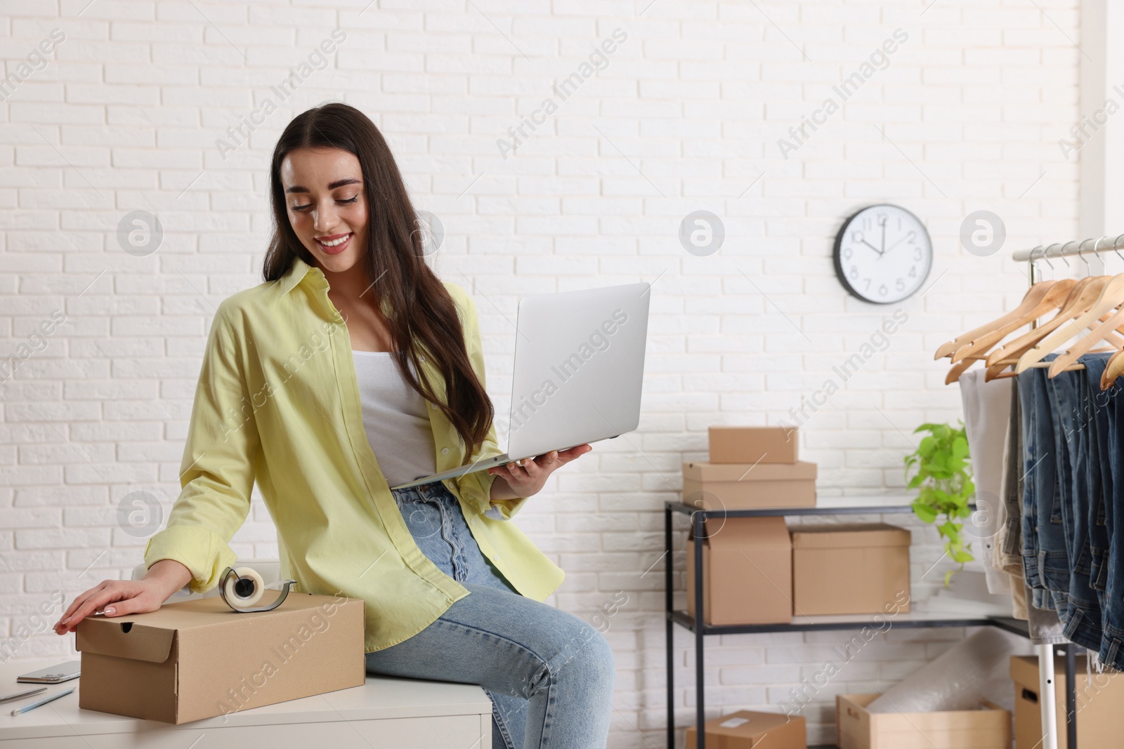 Photo of Clothes seller working with laptop in office, space for text. Online store