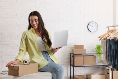 Photo of Clothes seller working with laptop in office, space for text. Online store