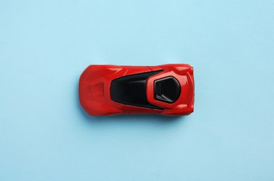 One red car on light blue background, top view. Children`s toy