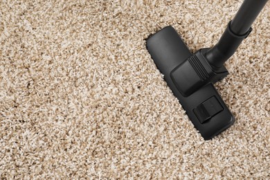Photo of Hoovering carpet with modern vacuum cleaner indoors. Space for text