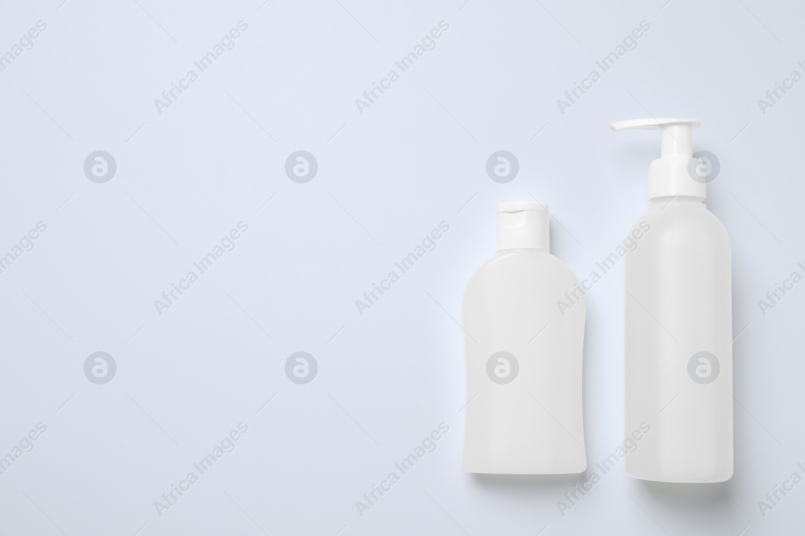 Photo of Bottles with different cosmetic products on white background, flat lay. Space for text