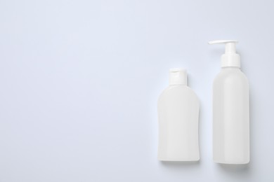 Photo of Bottles with different cosmetic products on white background, flat lay. Space for text