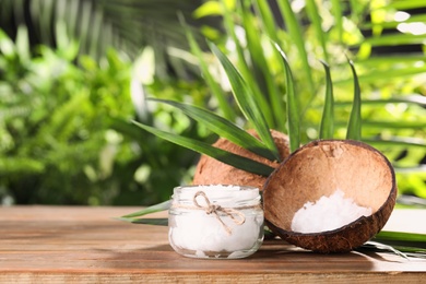 Composition with natural organic coconut oil on wooden table. Space for text