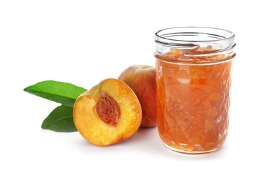 Jar with peach jam and fresh fruit on white background