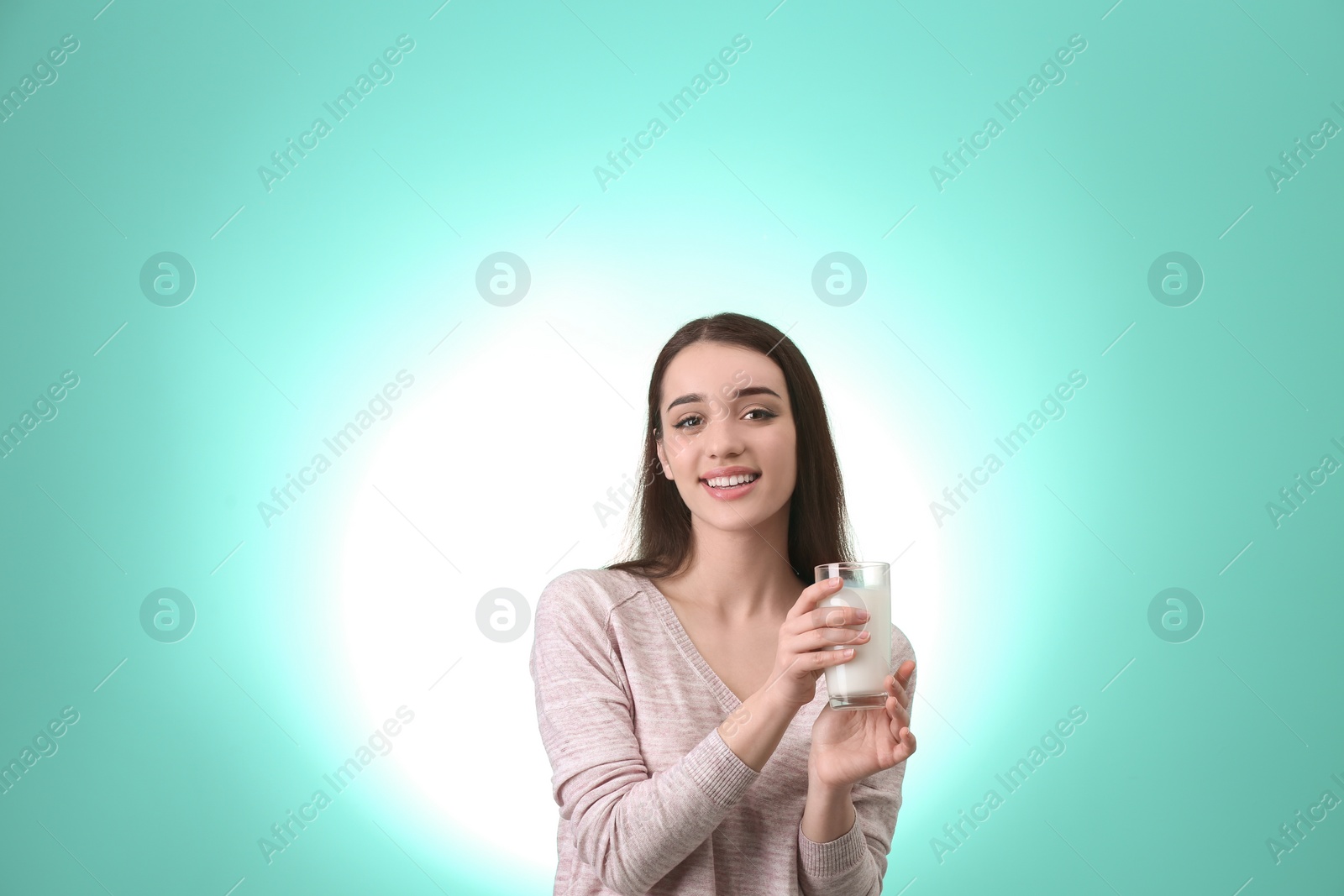 Photo of Beautiful young woman drinking milk on color background