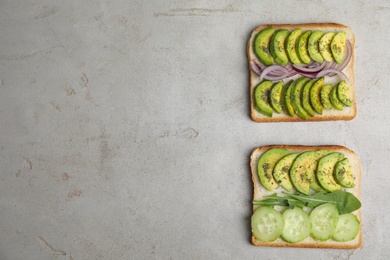 Photo of Tasty avocado toasts on light grey table, flat lay. Space for text