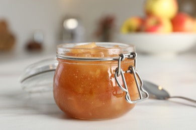 Photo of Delicious apple jam on white table, closeup