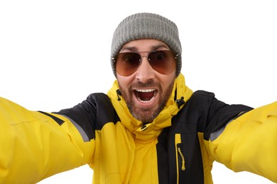 Smiling man in hat and sunglasses taking selfie on white background