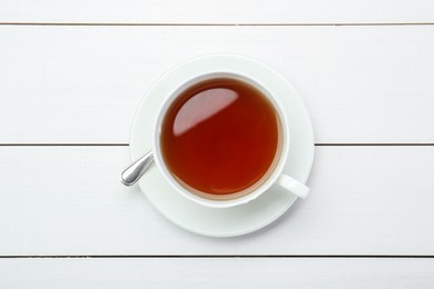 Aromatic tea in cup on white wooden table, top view