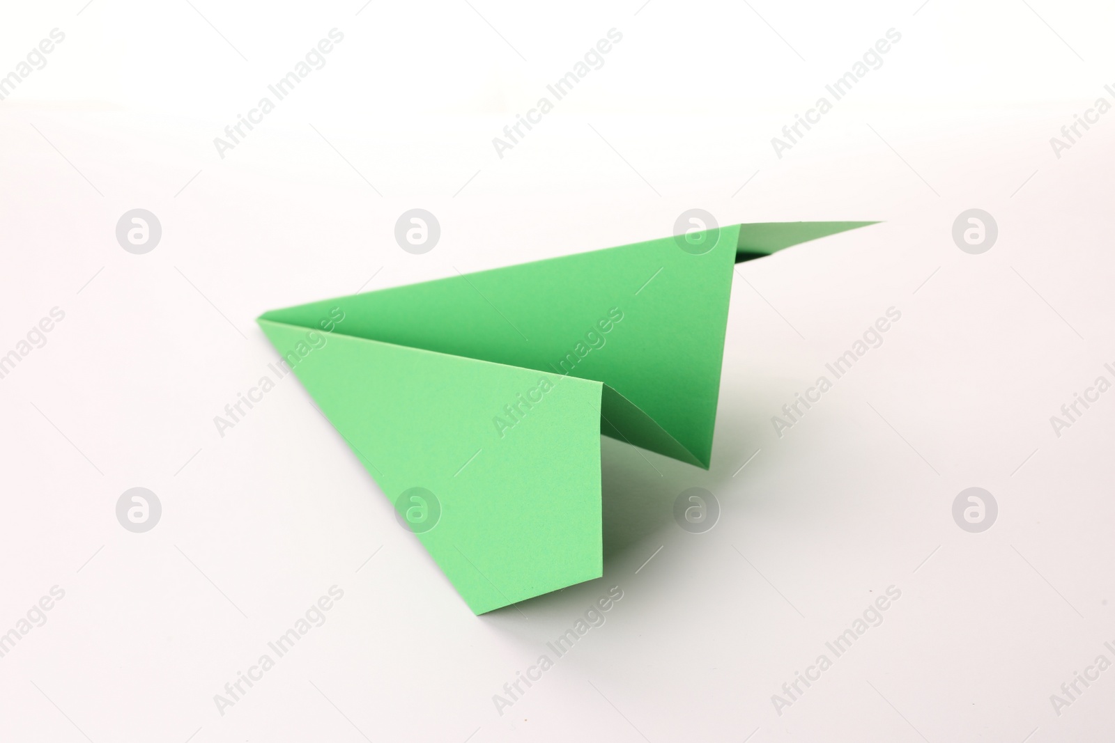 Photo of Handmade green paper plane isolated on white