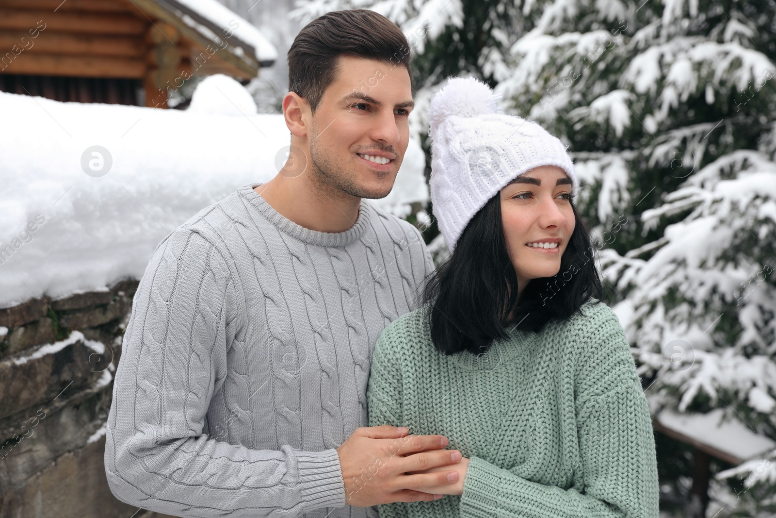 Photo of Happy couple in warm sweaters outdoors on winter day