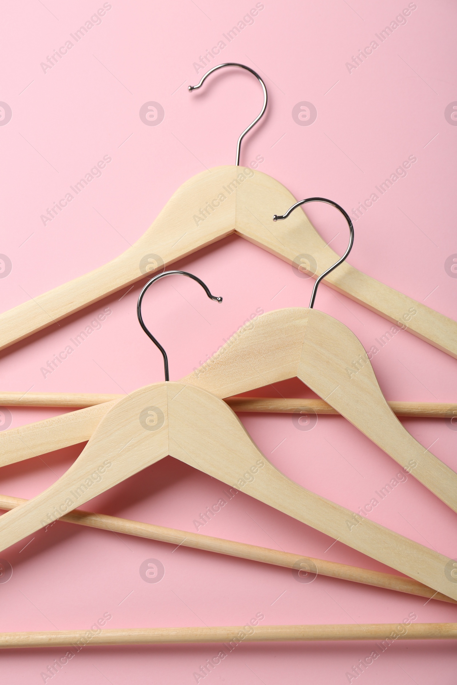 Photo of Wooden hangers on pink background, top view