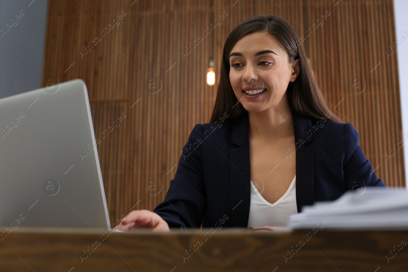 Photo of Businesswoman working with laptop and documents at table in office