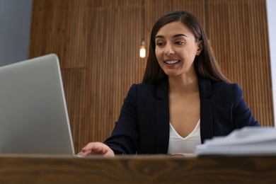 Photo of Businesswoman working with laptop and documents at table in office