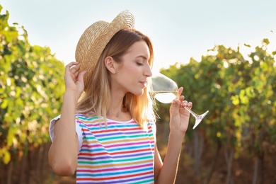 Photo of Young beautiful woman tasting wine at vineyard on sunny day