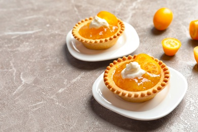 Photo of Tasty tartlets with jam on grey background