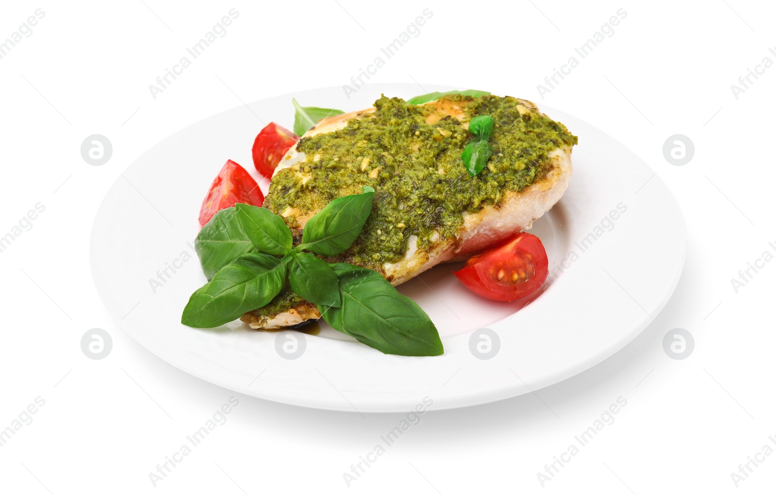 Photo of Delicious chicken breast with pesto sauce, tomatoes and basil isolated on white