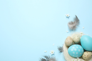 Flat lay composition with Easter eggs on light blue background. Space for text