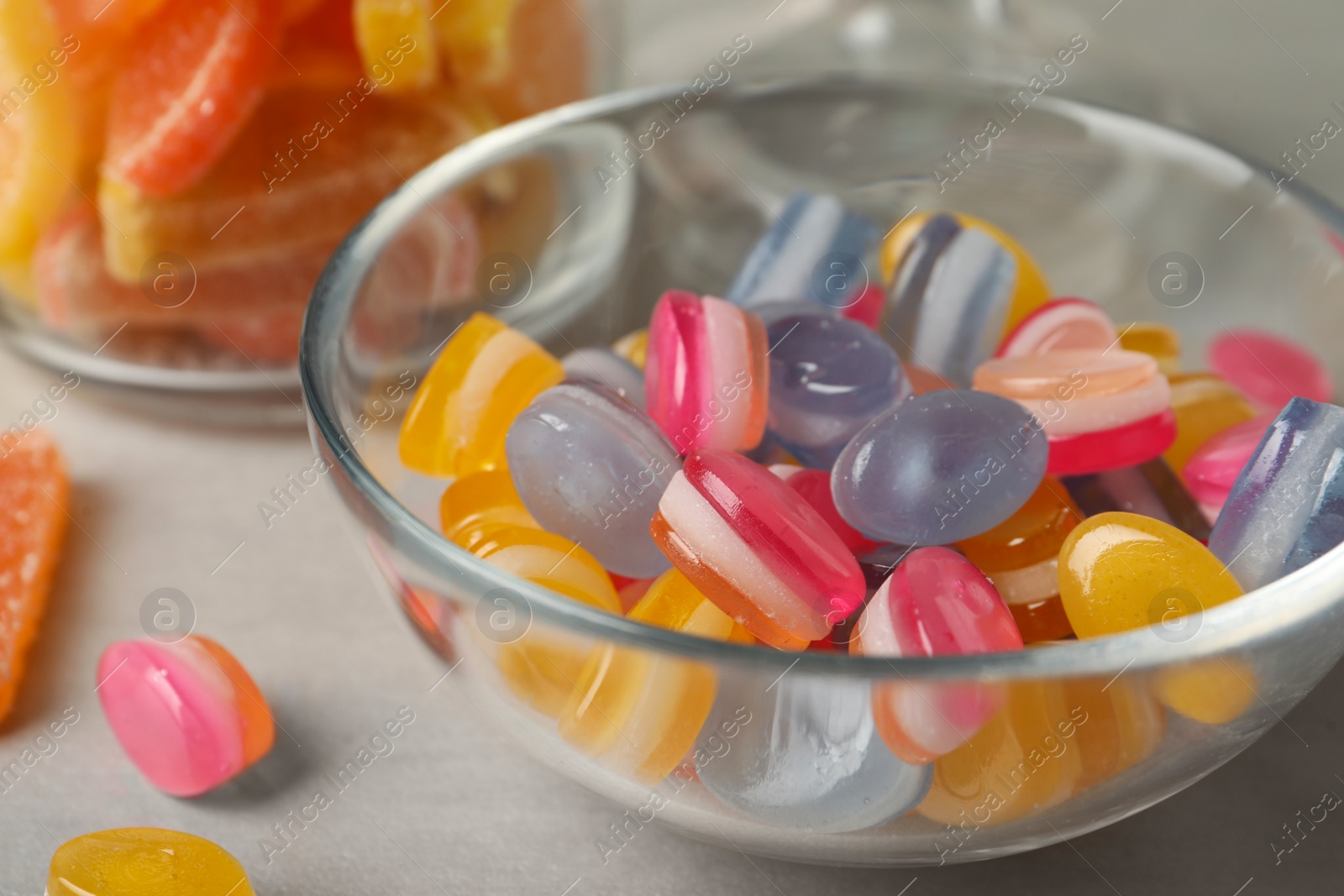 Photo of Tasty colorful sweets on light grey table, closeup