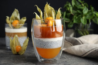 Delicious dessert decorated with physalis on grey table