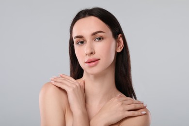 Portrait of beautiful young woman on light grey background