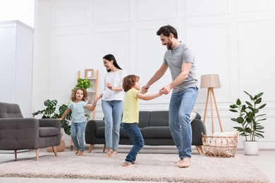 Photo of Happy family dancing and having fun in living room