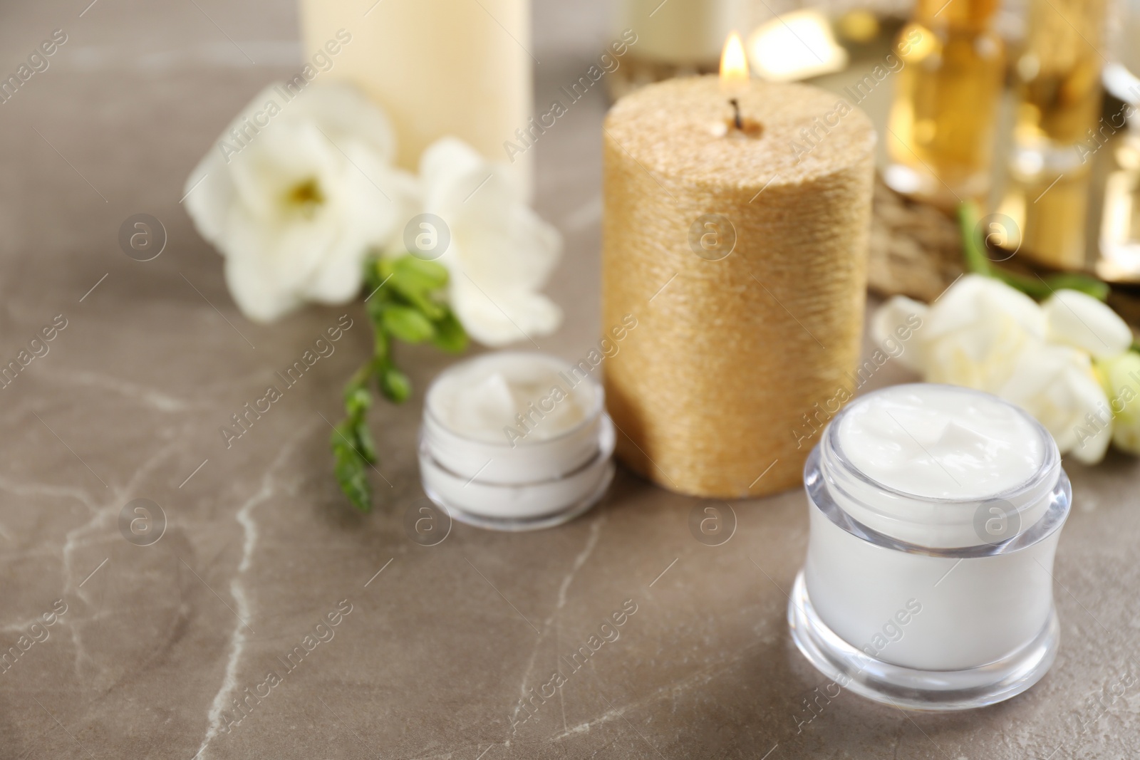 Photo of Beautiful spa composition with cosmetic products and candle on table. Space for text