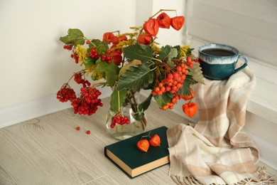 Photo of Beautiful autumn composition with cup of drink and book indoors