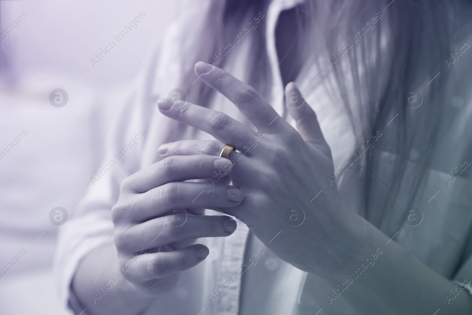 Image of Woman taking off wedding ring indoors, closeup. Cheating and breakup