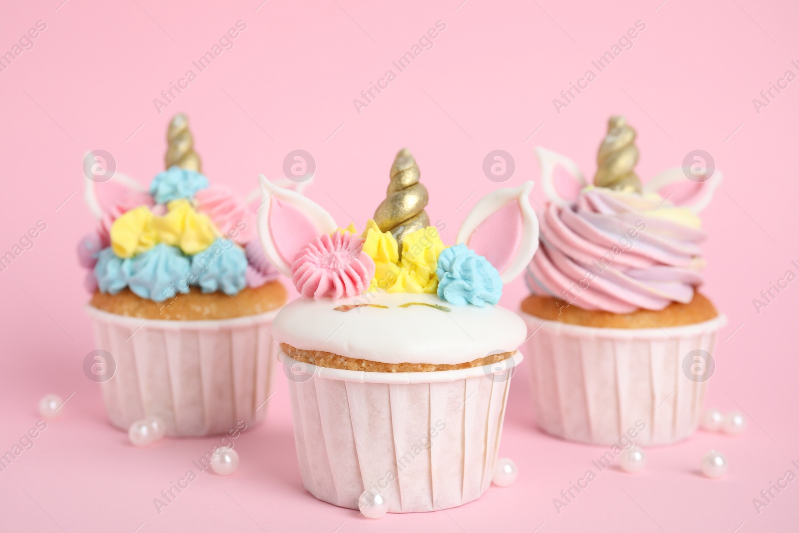 Photo of Cute sweet unicorn cupcakes on pink background